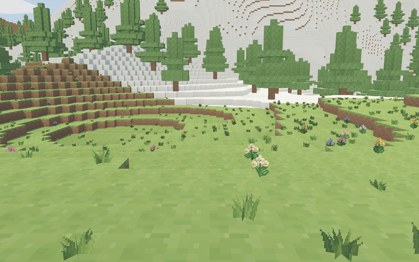 A wide meadow valley with woodland on the far slope.